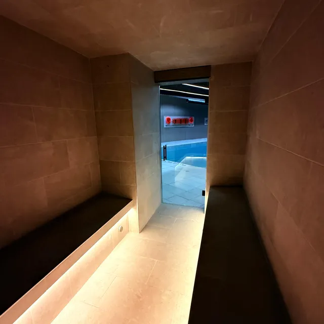 Wellness corridor glowing with ambient pool light