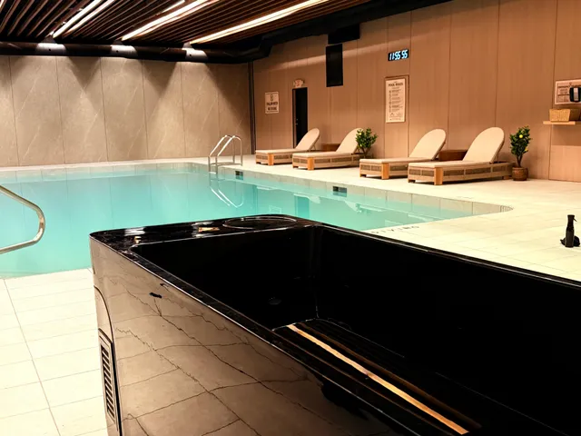 Indoor pool with loungers along the tiled deck